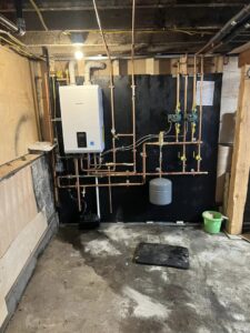 A boiler and tankless water heater system with new copper piping by Quality Comfort Inc. in Aston, PA