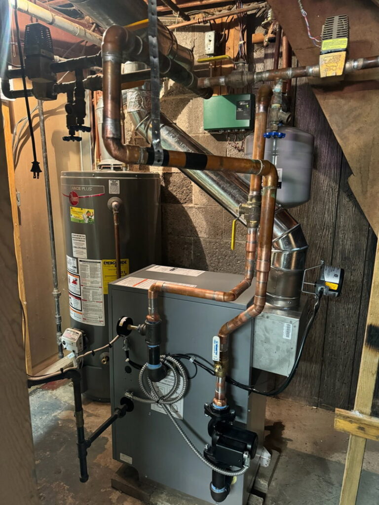 A boiler and water heater installation with associated piping by Empire Heating & Air Conditioning in Decatur, GA