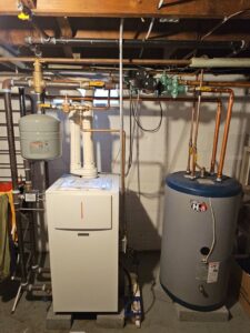 A new boiler and water heater system installed in a residential basement by Heat Pump Pros in Hartford, CT.