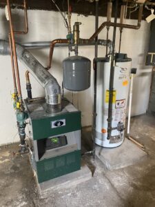 A boiler and water heater installed in a utility area by Kane Heating & Air in Mountain Top, PA.