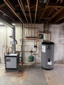 A boiler and water heater system with copper piping installed in a basement by True Heating and Cooling in Greenfield, IN.