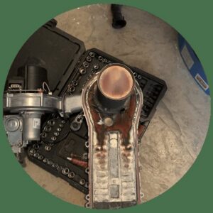 Disassembled boiler burner assembly during repair or maintenance by Q1 Mechanical Services, LLC in Wasilla, AK