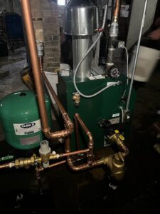 A boiler or furnace with copper piping and an expansion tank installed by Done Right Air in West Allis, WI