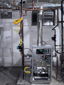 A boiler or furnace system with exposed wiring and tools during a repair service by Primary Air Home Services in Aurora, CO.
