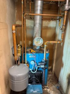 An older boiler heating system with copper piping, maintained by ECA DuctWorks in Reston, VA