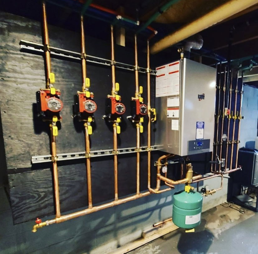 A comprehensive boiler and hydronic heating system with multiple pumps and copper piping installed by Allied Heating and Air Conditioning in Port Richey, FL.