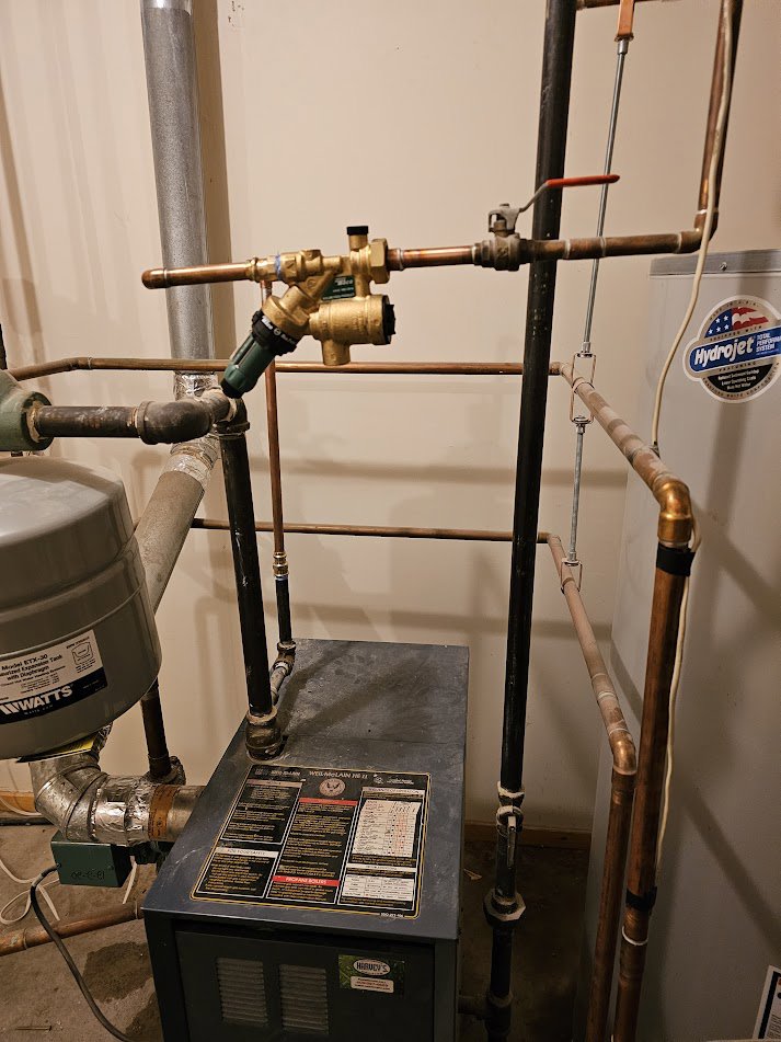 A boiler unit with an expansion tank and copper piping, installed by Perfect Temp LLC in Bozeman, MT.
