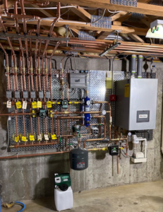 A newly installed boiler and intricate copper piping system in a utility room by New Yorker Boiler in Lancaster, PA