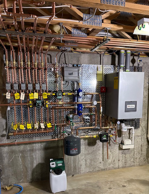 A newly installed boiler and intricate copper piping system in a utility room by New Yorker Boiler in Lancaster, PA