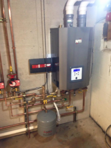 Detailed view of copper piping, valves, and gauges for a boiler system installed by Green Planet Solutions Corporation in Moscow, PA.
