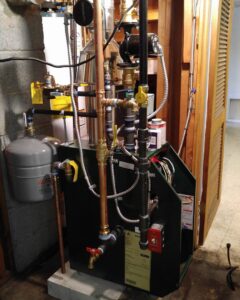 A complex boiler heating system with pipes and an expansion tank, installed or serviced by Batista Heating & Cooling, LLC in Charlotte, NC.