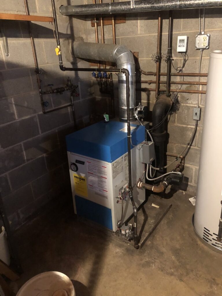 A complete boiler system and water heater installation in a utility room by Ohio City Heating and Cooling in Cleveland, OH.