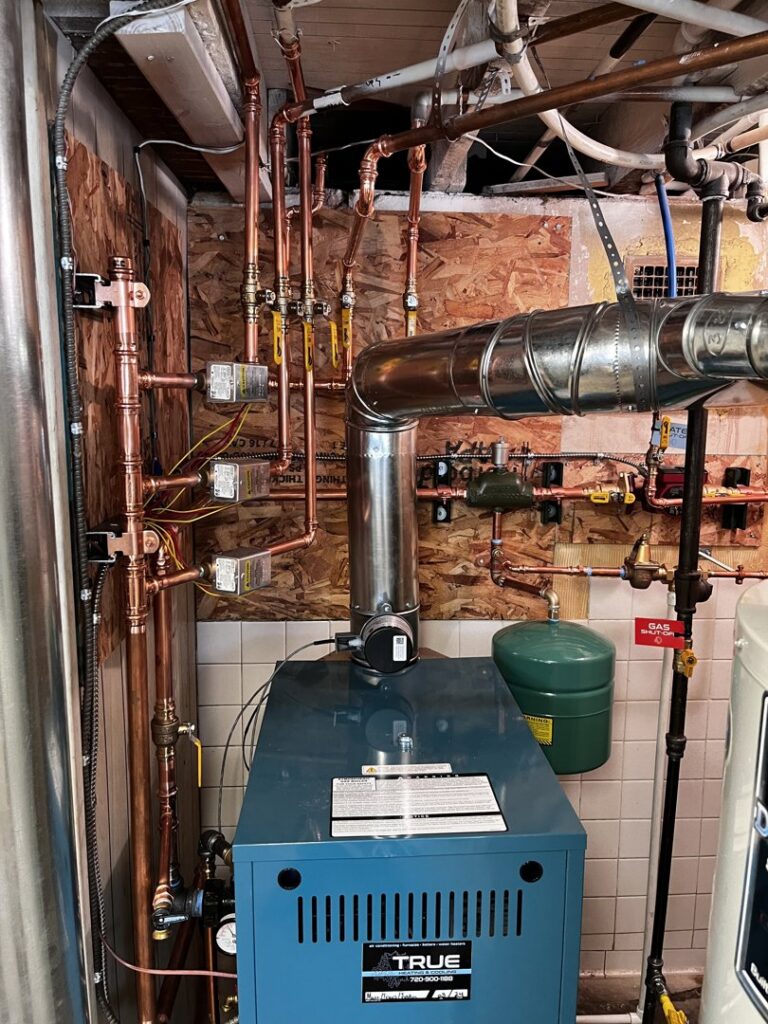 A boiler heating system with extensive copper piping installed by True Heating and Cooling in Greenfield, IN.