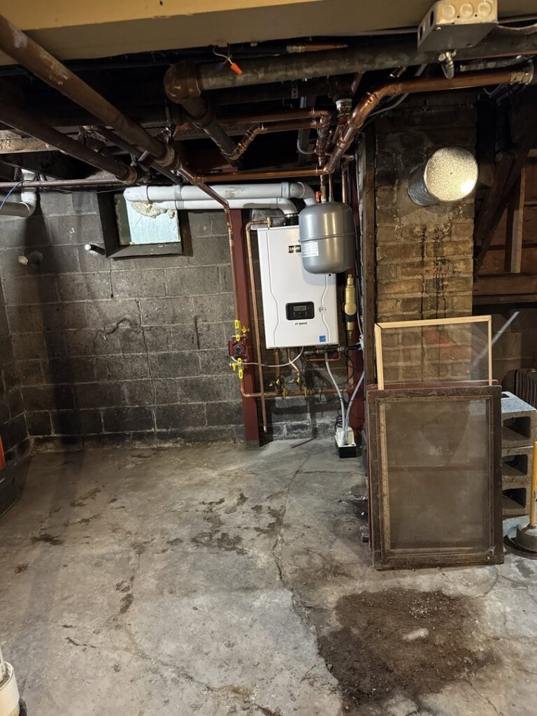 A newly installed boiler and water heater system in a basement by Aire Serv of Fargo, ND.