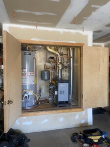 A mechanical closet showing a water heater and a boiler or furnace unit installed by Santa Fe Heating & Cooling LLC in Santa Fe, NM.