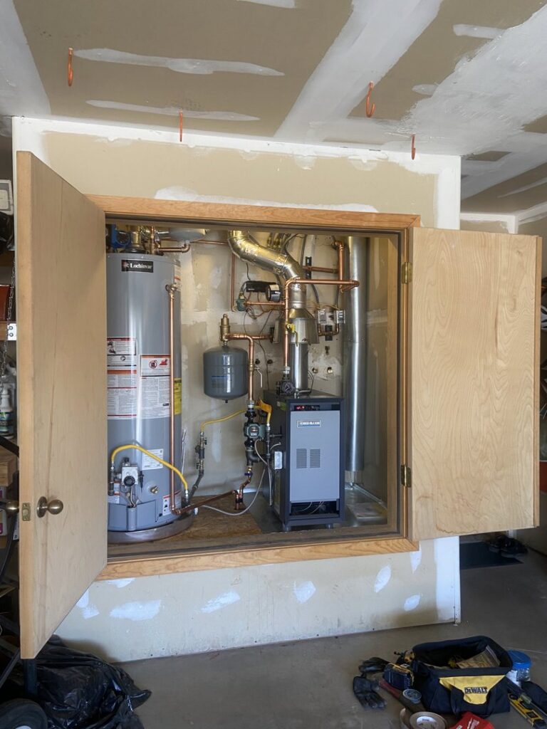 A mechanical closet showing a water heater and a boiler or furnace unit installed by Santa Fe Heating & Cooling LLC in Santa Fe, NM.