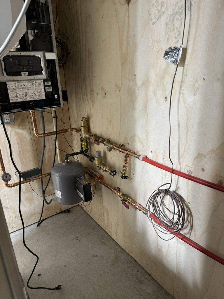 A boiler or water heating system with copper and PEX piping installed by Dischler Heating-Cooling & Fireplaces in Prairie du Sac, WI.
