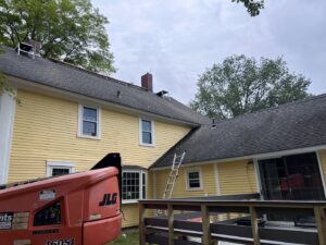A boom lift and ladders set up for chimney or roof work on a house by Granite State Chimney in Manchester, NH