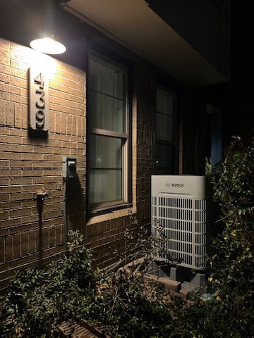 An outdoor Bosch heat pump unit installed next to a residential building by Just Heat Pumps in Denver, CO.