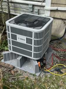A Bosch outdoor HVAC unit being serviced with gauges connected by D and C Mechanical, Inc. in Tewksbury, MA.