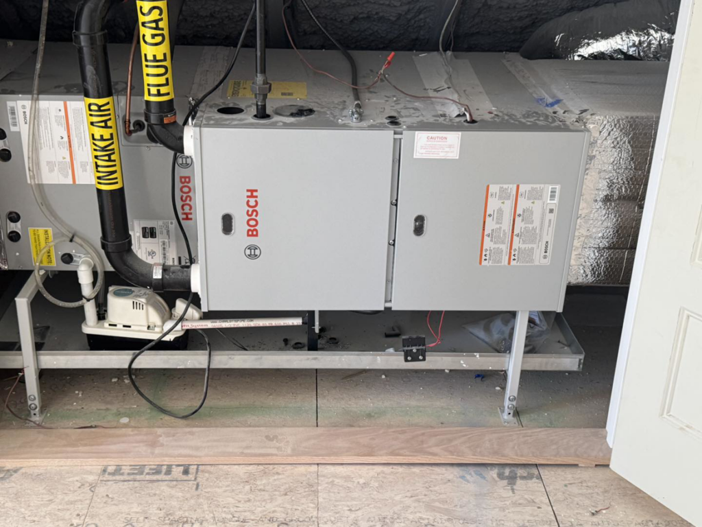 An indoor Bosch HVAC furnace and air handler unit with ductwork installed by D and C Mechanical, Inc. in Tewksbury, MA.