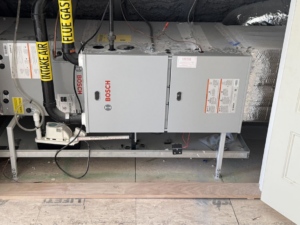 An indoor Bosch HVAC furnace and air handler unit with ductwork installed by D and C Mechanical, Inc. in Tewksbury, MA.