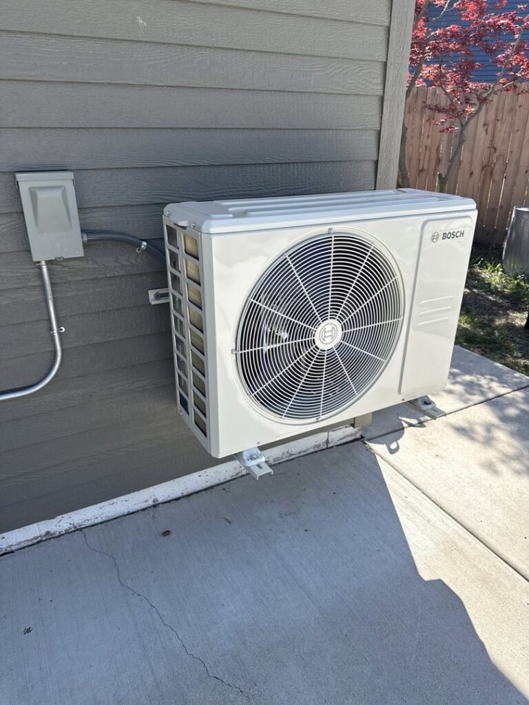 A Bosch mini-split outdoor unit installed on the side of a building by Total HVAC - Heating and Cooling in Nashville, TN.