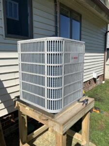 A Bosch outdoor air conditioning unit installed on a wooden stand by Hendrix Heating & Air in Newport News, VA.
