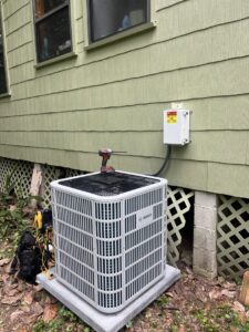 A Bosch outdoor AC unit being installed or serviced next to a house by McGuffee's Air Conditioning and Heating in Gulfport, MS