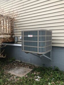 A Bosch outdoor air conditioning unit wall-mounted on a residential building by Simply Installs Heating & Air Conditioning in Shortsville, NY.
