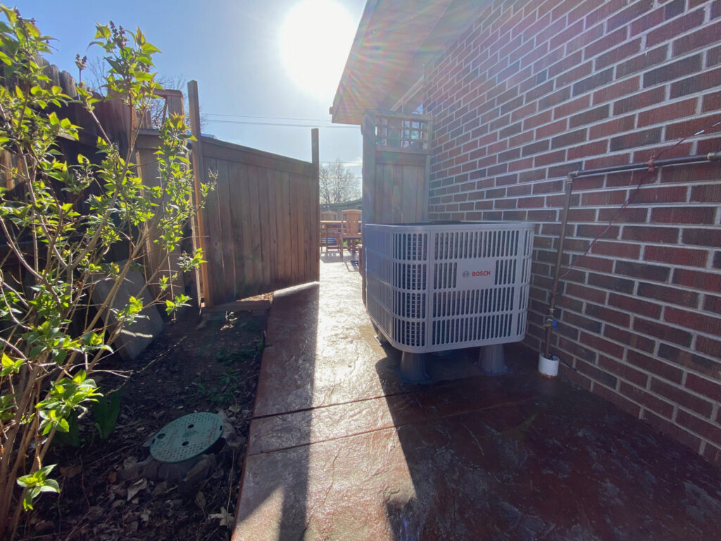 A Bosch outdoor HVAC unit installed next to a home by Comfy Cave Heating and Air Conditioning in Arvada, CO.
