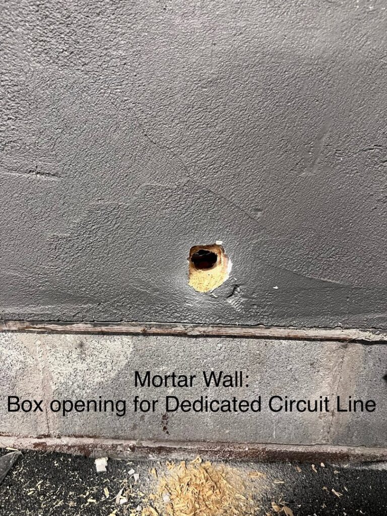 A box opening cut into a mortar wall for a dedicated circuit line by Fuse Electrical LLC in Rochester, NY