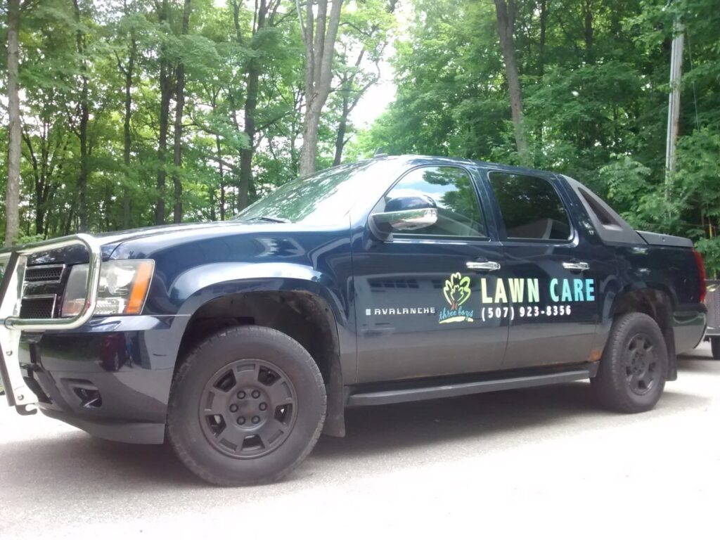A branded Three Boys Lawncare truck, ready for service in Rochester, MN, parked on a residential street.