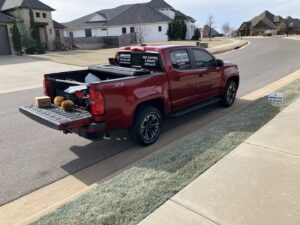 An Absolute Pest Solutions branded service truck with equipment in the bed, parked on a residential street in Piedmont, OK.