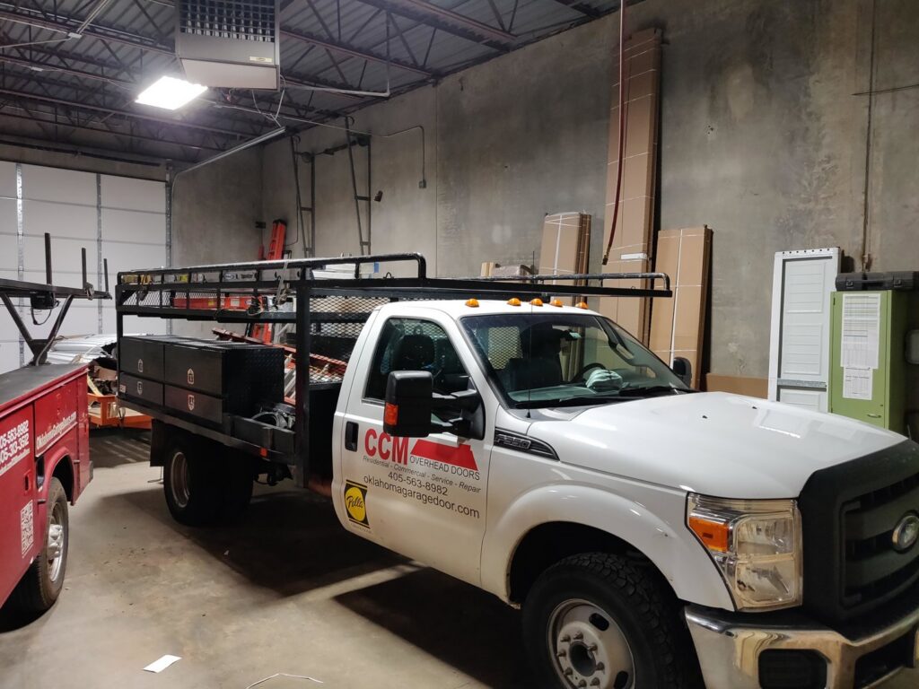 A branded service truck of CCM Overhead Doors parked inside their warehouse in Oklahoma City, OK