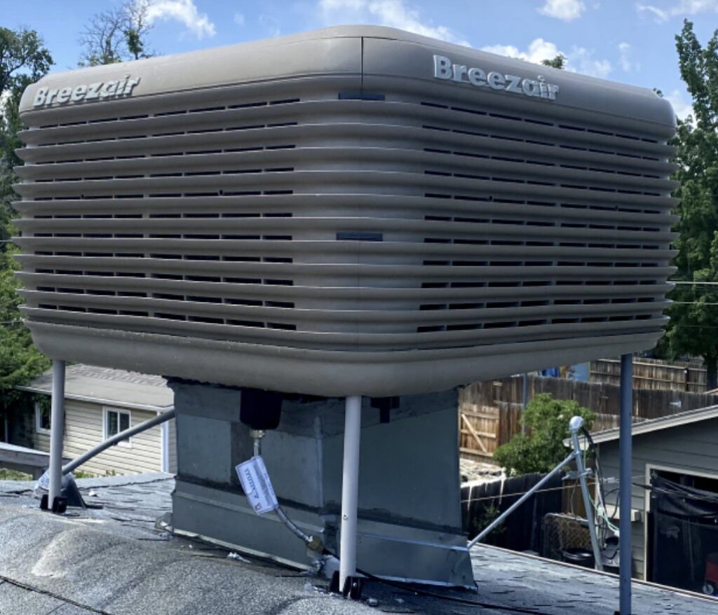 A Breezair evaporative cooler unit installed on a residential rooftop by Husky Heating and Cooling in Westminster, CO.