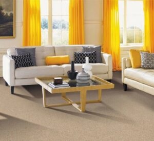 A bright living room with new light brown carpet and yellow curtains by Wall To Wall Carpet One Floor & Home in Eau Claire, WI