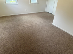 Bright room with clean carpet, windows, and a closet, serviced by The Gold Standard Carpet Cleaning in Kansas City, MO.