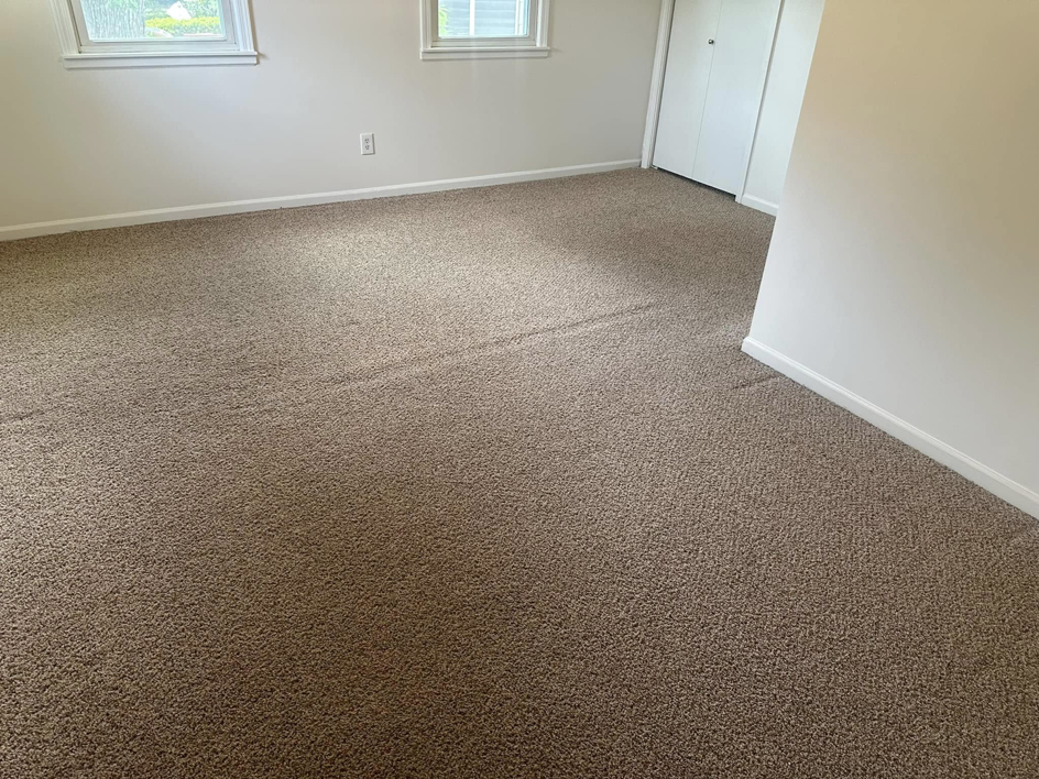 Bright room with clean carpet, windows, and a closet, serviced by The Gold Standard Carpet Cleaning in Kansas City, MO.