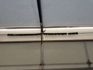 A broken garage door spring requiring repair, a common service provided by Absolute Garage Doors LLC AZ in Mesa, AZ