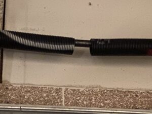 A close-up view of a broken garage door spring, indicating a repair job by American Garage Door Service in Springfield, MO.