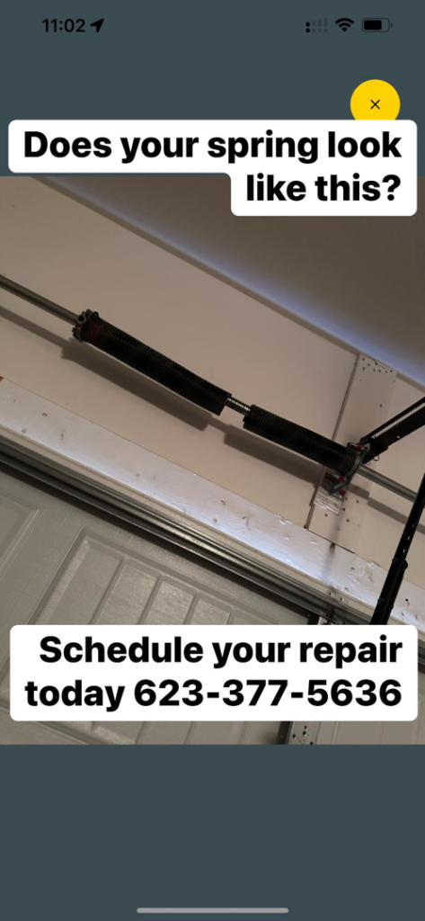 A close-up view of a broken garage door torsion spring, indicating a necessary repair by Heritage Garage Door Service LLC in Phoenix, AZ.