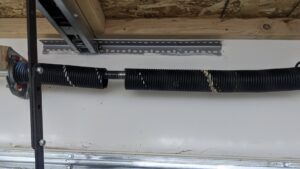 A close-up of a broken garage door spring, indicating a need for repair by Overhead Door Company of Everett, Inc in Everett, WA.
