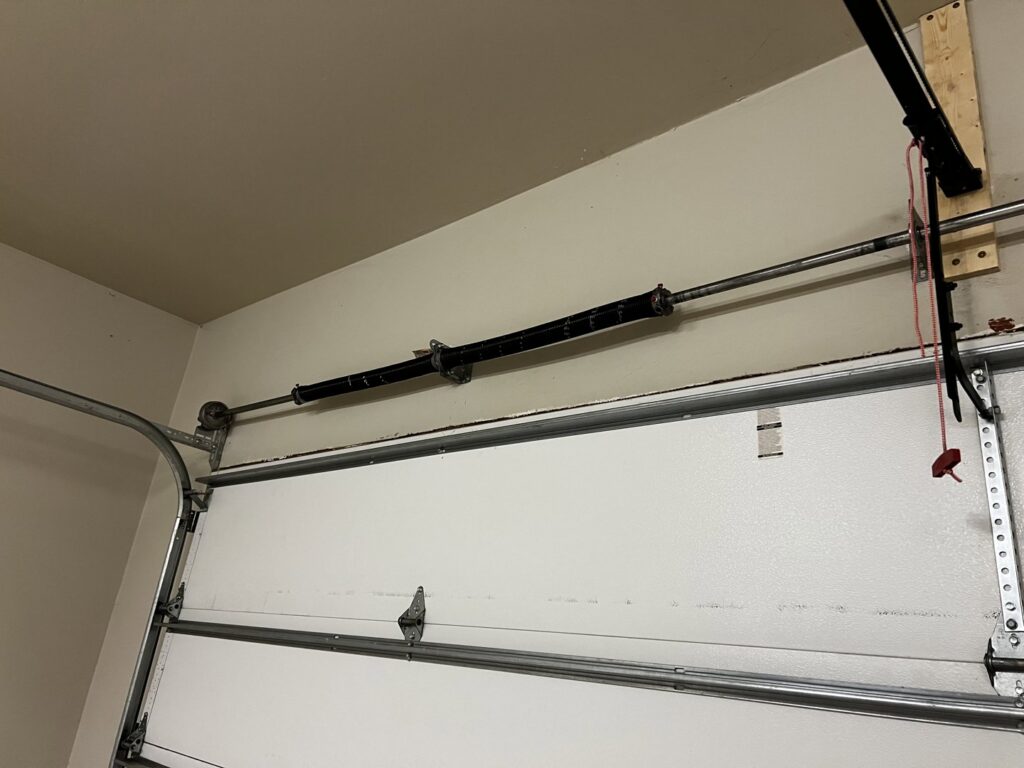 A close-up of a broken garage door spring, indicating a need for repair by Rhino Garage Doors LLC OKC in Edmond, OK.