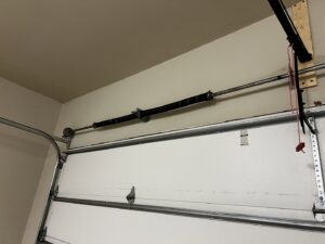 A close-up of a broken garage door spring, indicating a need for repair by Rhino Garage Doors LLC OKC in Edmond, OK.