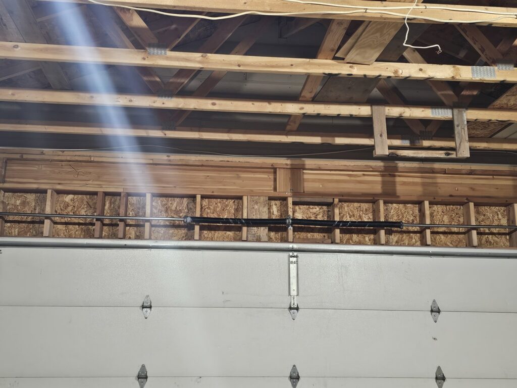 A broken garage door torsion spring system, indicating a need for repair by Garage Gecko in Spokane, WA.