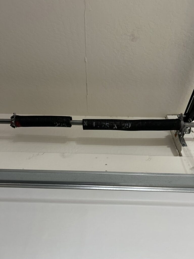 A broken garage door torsion spring, indicating a need for repair by 4 Sons Garage Door in Phoenix, AZ.