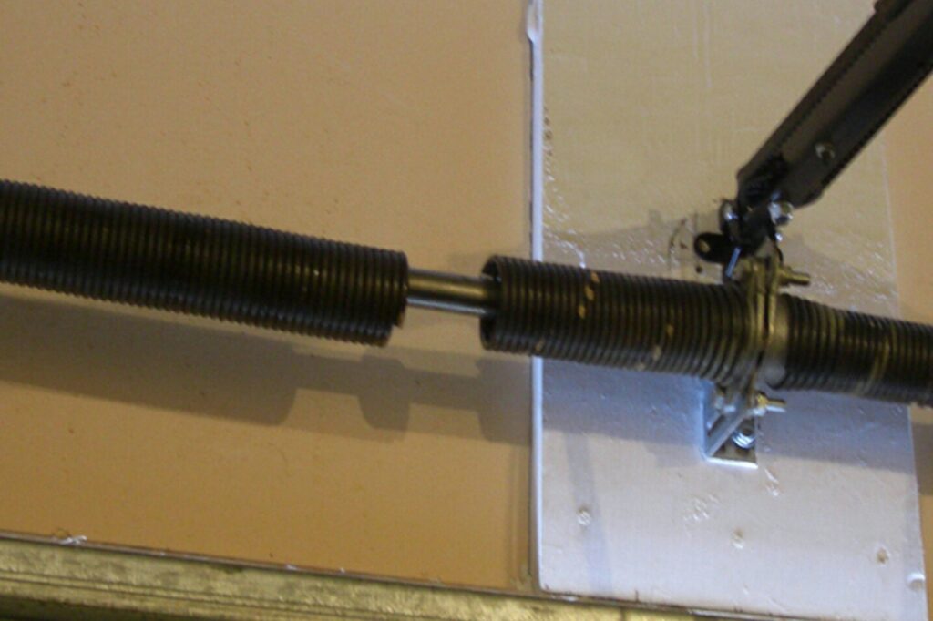 A close-up view of a broken garage door torsion spring, indicating a repair job by PRO-Line Garage Doors LLC in Richmond, KY.