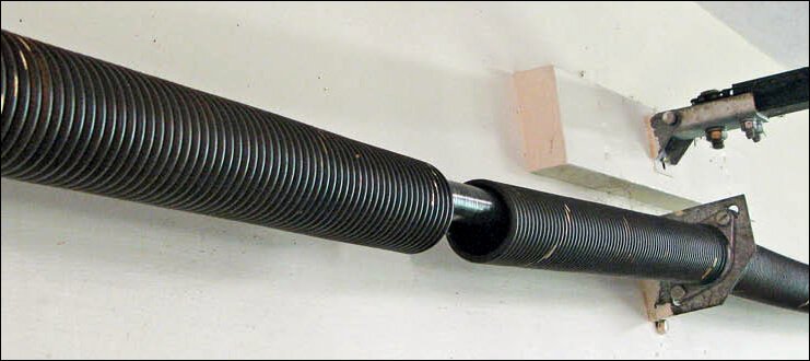A close-up of a broken garage door torsion spring needing repair from Tulsa Garage Door Doctor LLC in Tulsa, OK