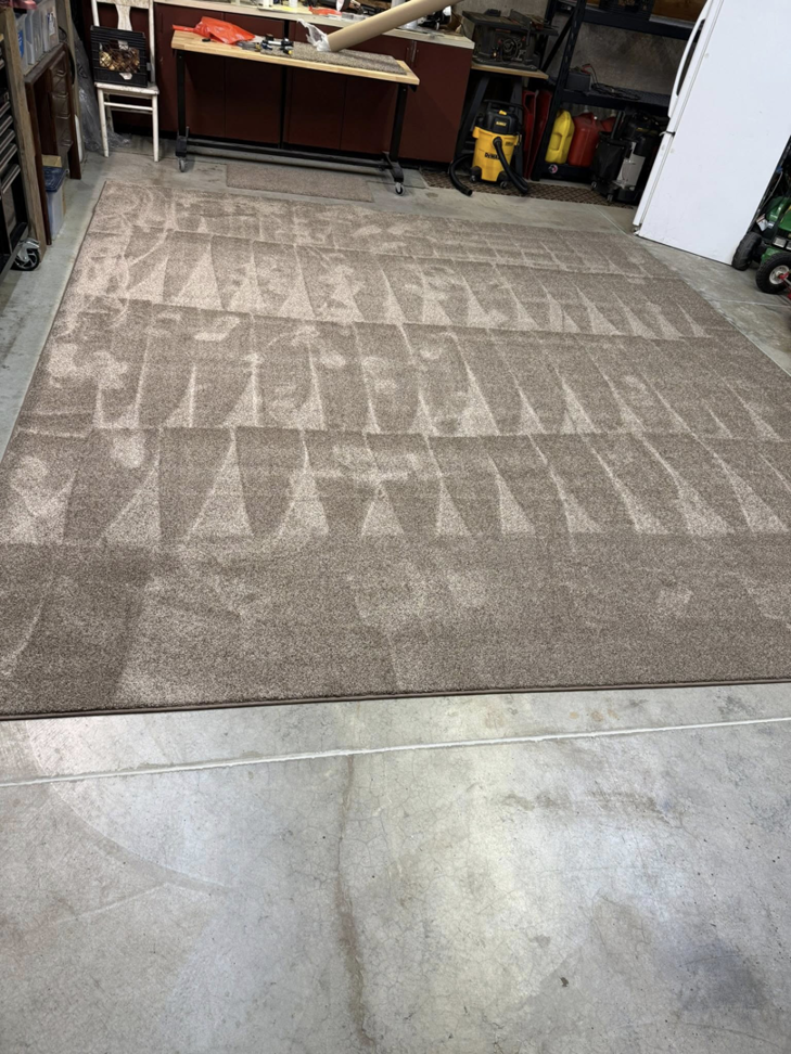 A large brown area rug with visible vacuum marks, prepared by Rug Edge Binding Company in Spokane, WA